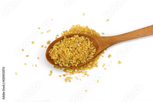  Uncooked bulgur in a wooden spoon isolated on white