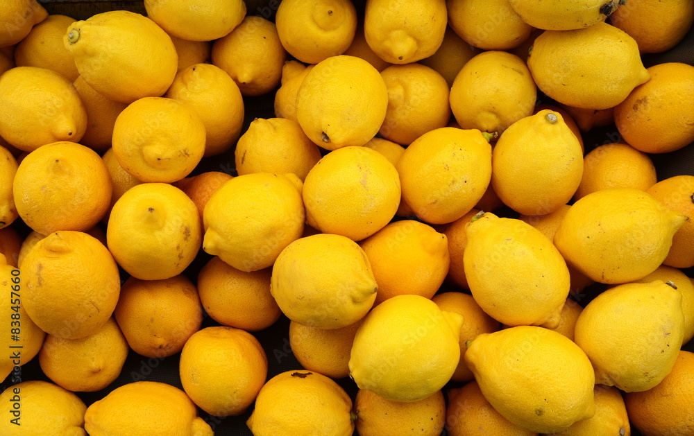 Colorful Display Of Lemons at fruit and vegetables street Market, organic ecological food from local producers. Ripe Yellow Lemons Close-up Background Or Texture. Lemon Harvest, Many Yellow Lemons. Colorful Display Of Lemons at fruit and vegetables street Market, organic ecological food from local producers. Ripe Yellow Lemons Close-up Background Or Texture. Lemon Harvest, Many Yellow Lemons.