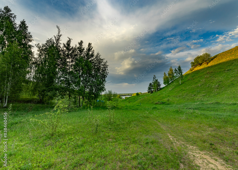 A picturesque path winds through a grassy meadow, leading toward a distant valley bathed in the warm glow of a spring day. A picturesque path winds through a grassy meadow, leading toward a distant valley bathed in the warm glow of a spring day.
