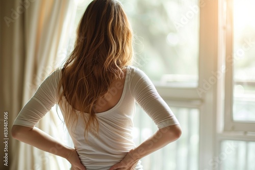 Woman stands by window with hands on hips Free Download Woman stands by window with hands on hips - GFXLoad