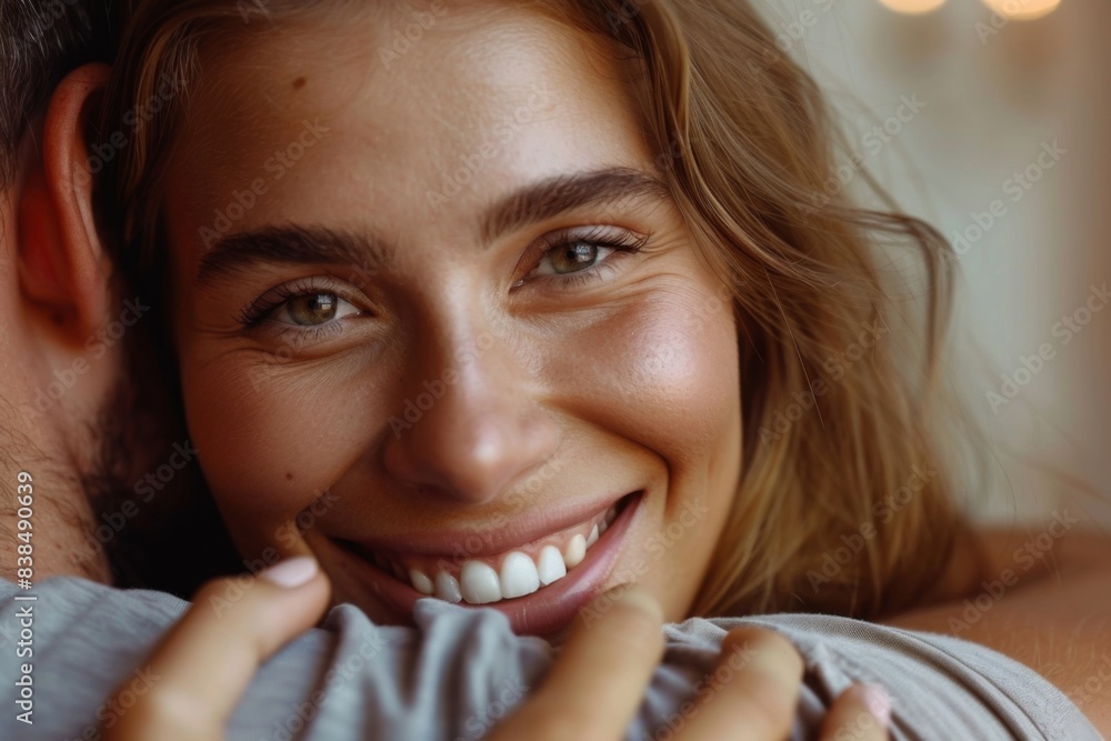 Joyful woman embraces man, showcasing bright smile and light eyes Joyful woman embraces man, showcasing bright smile and light eyes