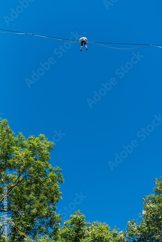 un funambule dans la nature. Funambule en extérieur naturel. Acrobate sur un fil en hauteur. Funambule sur une corde tendue. Funambulisme dehors.. Equilibre