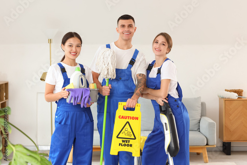 Team of young janitors with cleaning supplies in room © Pixel-Shot