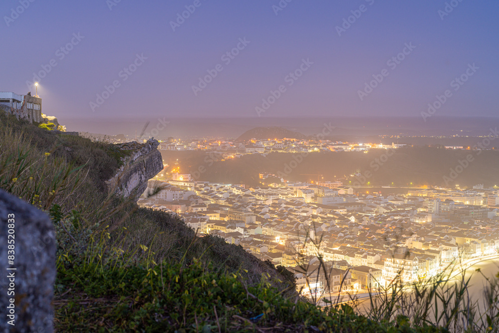 Obraz premium Night view of Nazaré, Portugal, from a high vantage point.
