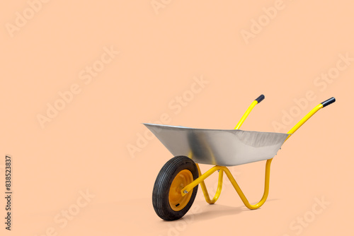 Empty wheelbarrow on beige background