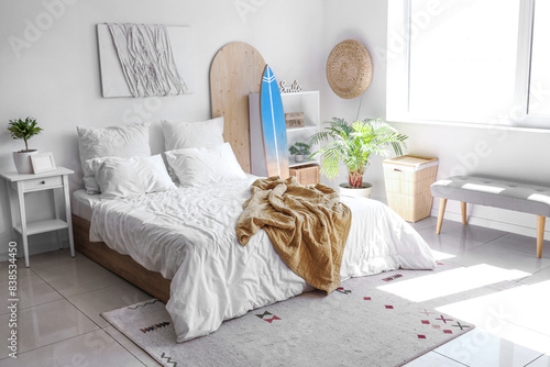 Photography Surfboard and large bed in interior of modern bedroom