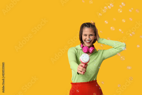 Teenage girl with soap bubb...