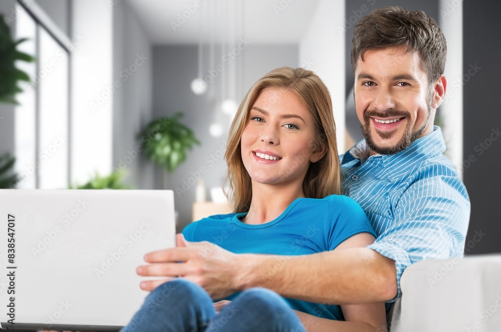 happy couple sitting together on sofa with laptop happy couple sitting together on sofa with laptop