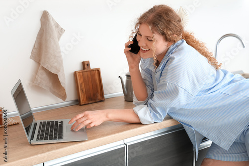 Young woman with laptop tal...