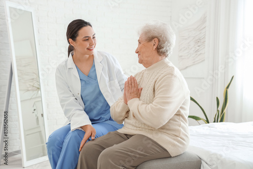 Physical therapist with senior woman sitting in bedroom