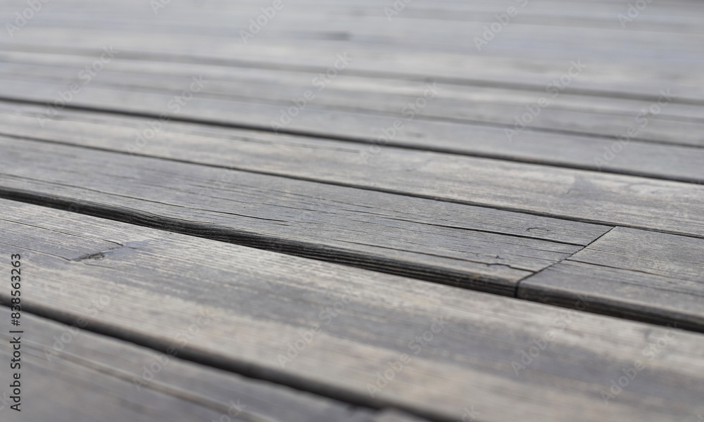 Fototapeta premium An old wooden gray pavement as a background. Photo in perspective with selective focus