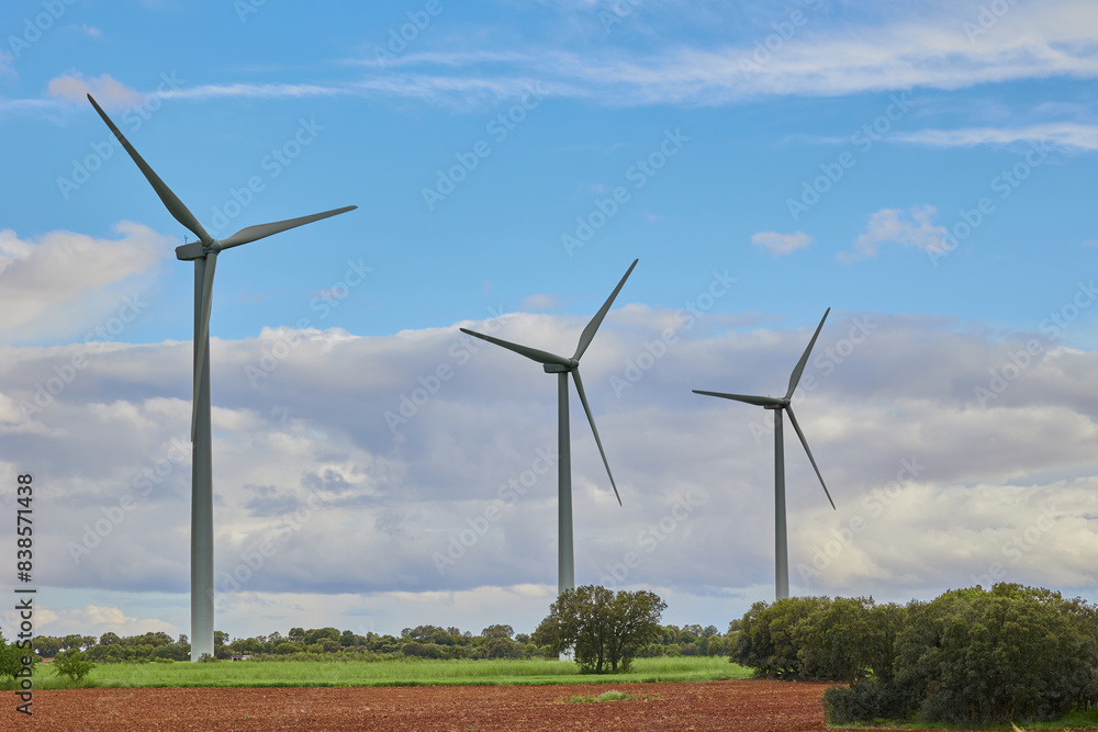 Wind farm in an agricultural field against cloudy sky Wind farm in an agricultural field against cloudy sky