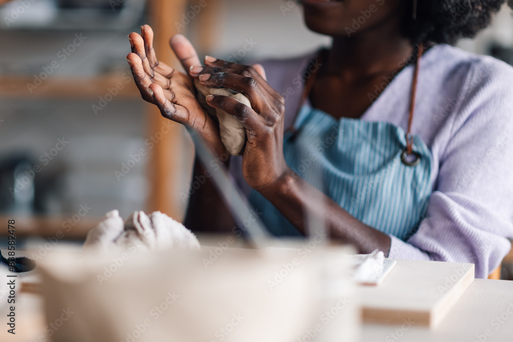 Obraz premium Close up of female diverse pottery class student's hands modeling clay