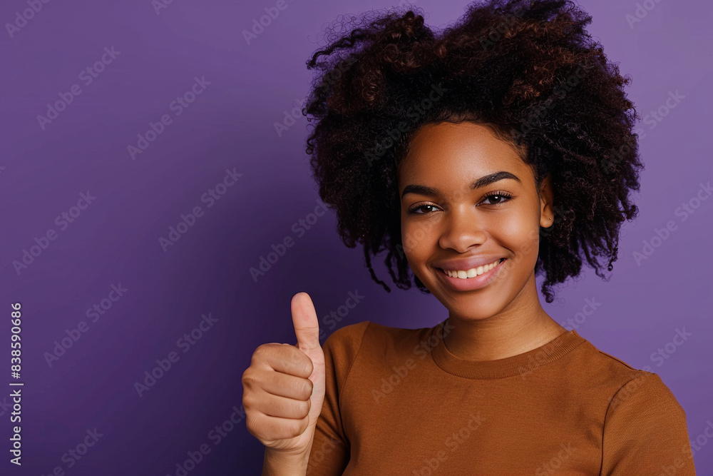 In a striking image set against a violet background, a pretty young woman exudes confidence and positivity as she showcases a thumbs-up gesture In a striking image set against a violet background, a pretty young woman exudes confidence and positivity as she showcases a thumbs-up gesture