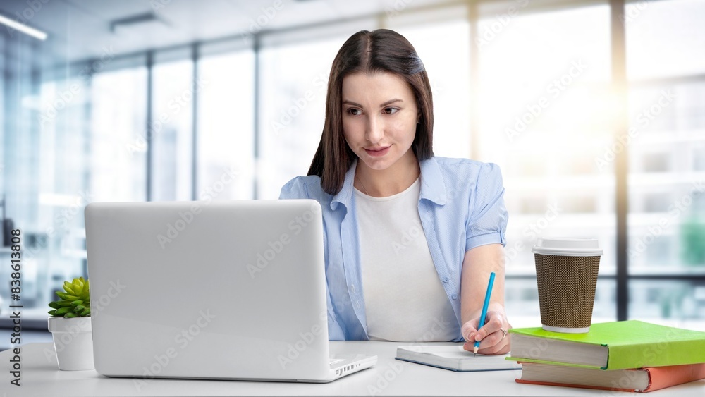 Woman working, checking emails sitting in an office Woman working, checking emails sitting in an office