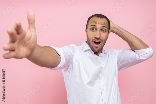 Shocked astonished man in white shirt making selfie
