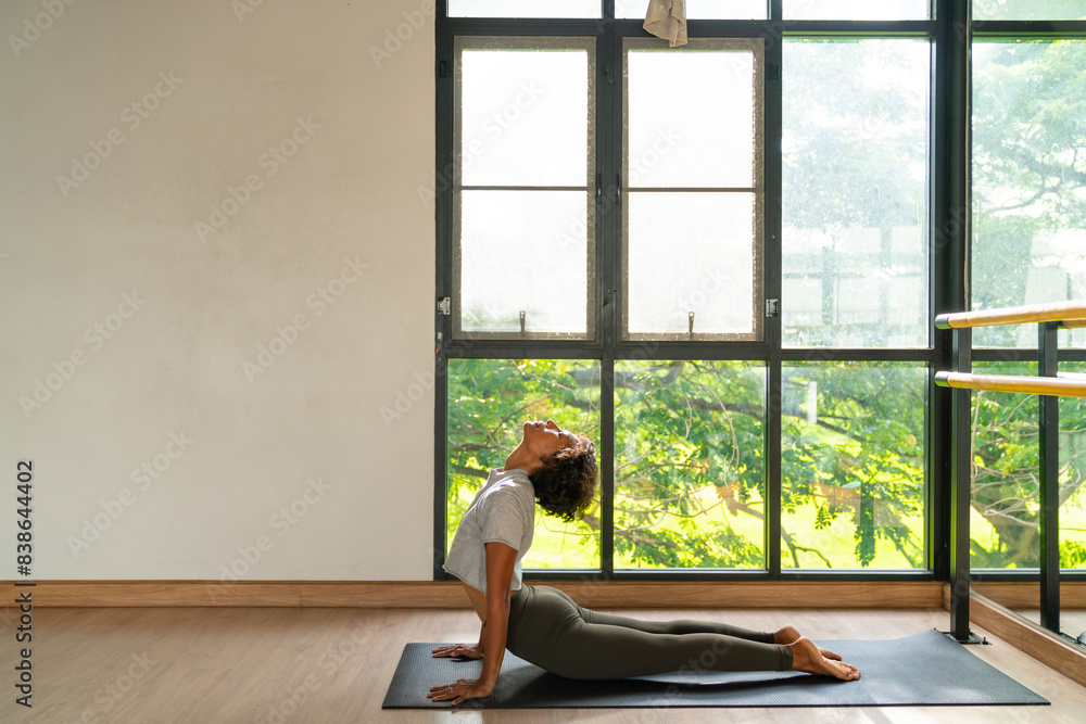 Asian woman in yoga clothes practice body stretching yoga exercise on yoga mat in yoga studio. Wellness people relax and enjoy healthy lifestyle sport training fitness workout and meditation at gym. Asian woman in yoga clothes practice body stretching yoga exercise on yoga mat in yoga studio. Wellness people relax and enjoy healthy lifestyle sport training fitness workout and meditation at gym.