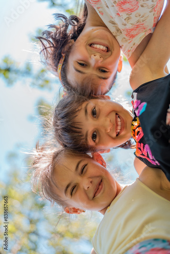 Happy children embracing each other having fun and smiling at camera, group of joyful kids playing together outside.