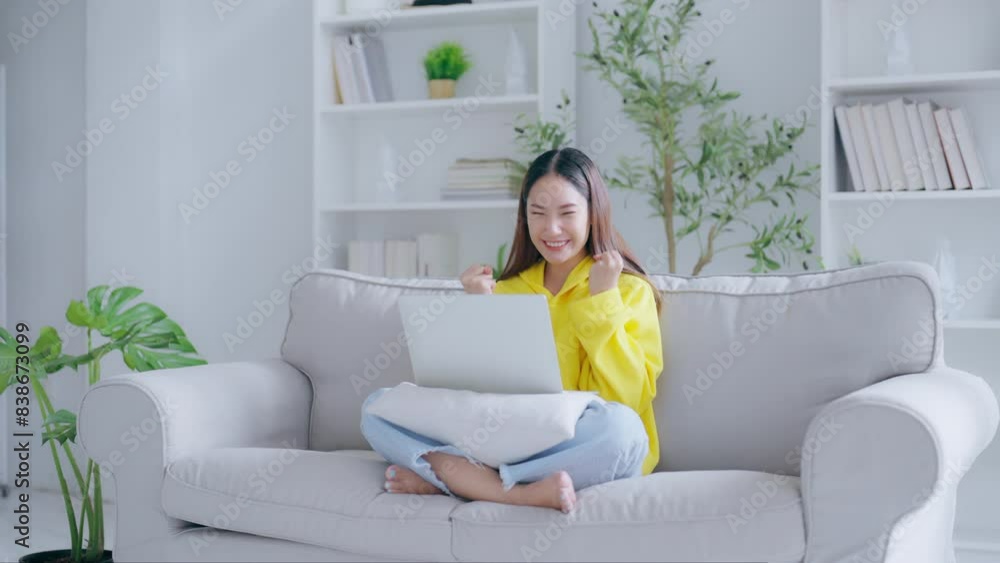 Happy euphoric young asian woman celebrating winning or getting ecommerce shopping offer on computer laptop. Excited happy girl winner looking at notebook celebrating success Happy euphoric young asian woman celebrating winning or getting ecommerce shopping offer on computer laptop. Excited happy girl winner looking at notebook celebrating success