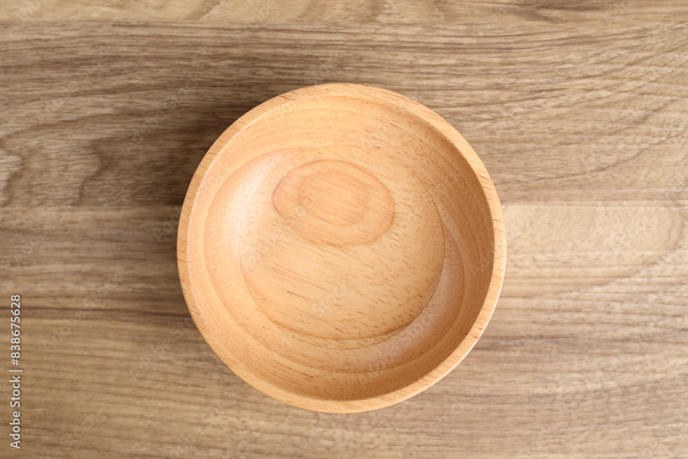 A wooden bowl on wooden background, Kitchen utensil, Table top view A wooden bowl on wooden background, Kitchen utensil, Table top view