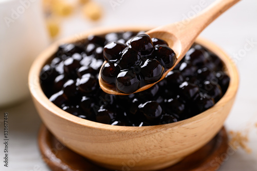Photos Black tapioca pearls or boba in wooden bowl with spoon, Ingredient in bubble tea