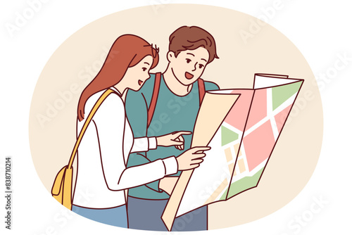 Tourist couple of man and woman looking at map choosing new city for travel or searching for hotel location. Guy and girl travel to new places enjoying vacation together on summer weekend