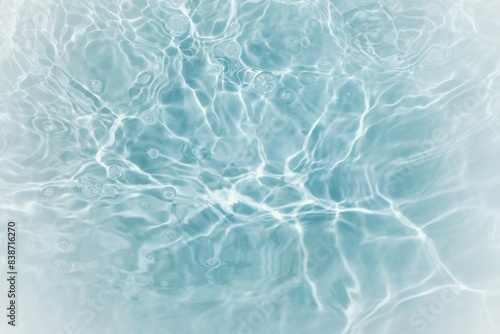 Blue water with ripples on the surface. Defocus blurred transparent blue colored clear calm water surface texture with splashes and bubbles. Water waves with shining pattern texture background. 