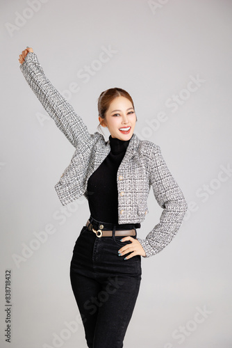 Asian smart happy entrepreneur business woman smile in casual suit gesture aised hands celebrating success and looking at camera on isolated grey background. Use for advertising © Auttapol