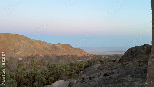 Morocco rural life historical landscape of date palm grove terraced garden in mountain desert wide view panoramic landscape of evening from the high mud brick clay house cube architecture design Iran photo