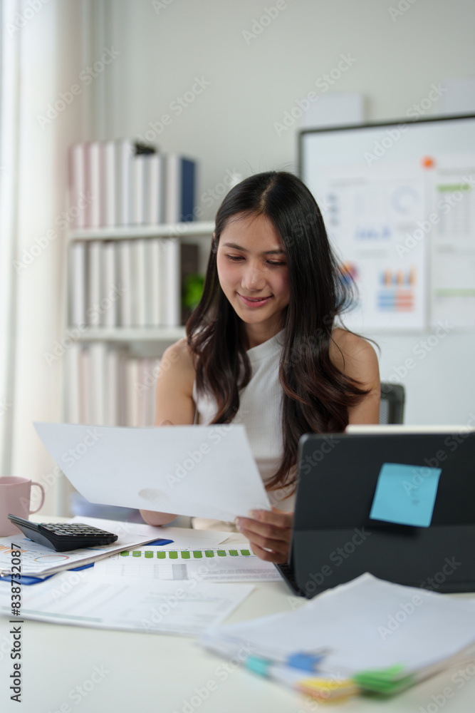Confident businesswoman working with laptop and documents in home office, thinking, analyzing work happily. Confident businesswoman working with laptop and documents in home office, thinking, analyzing work happily.