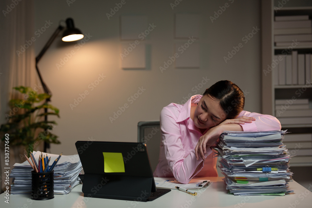 Tired Asian business woman Stress from paperwork, headaches, sleepiness on piles of documents. Tired of sitting at a desk for a long time, office syndrome concept. Tired Asian business woman Stress from paperwork, headaches, sleepiness on piles of documents. Tired of sitting at a desk for a long time, office syndrome concept.