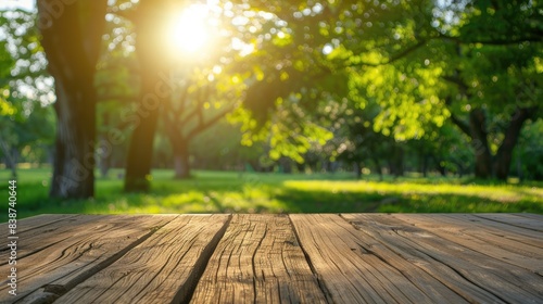 Spring summer beautiful nature background with blurred park trees in sunlight and empty wooden table 