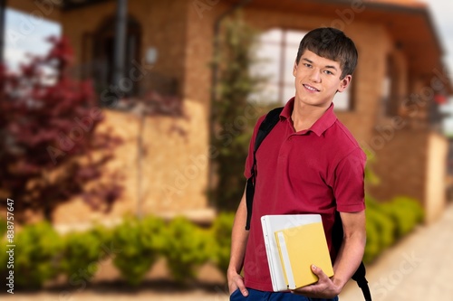 Young happy male student at the university campus. photo