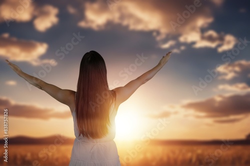 Young happy woman outstretched arms on big field