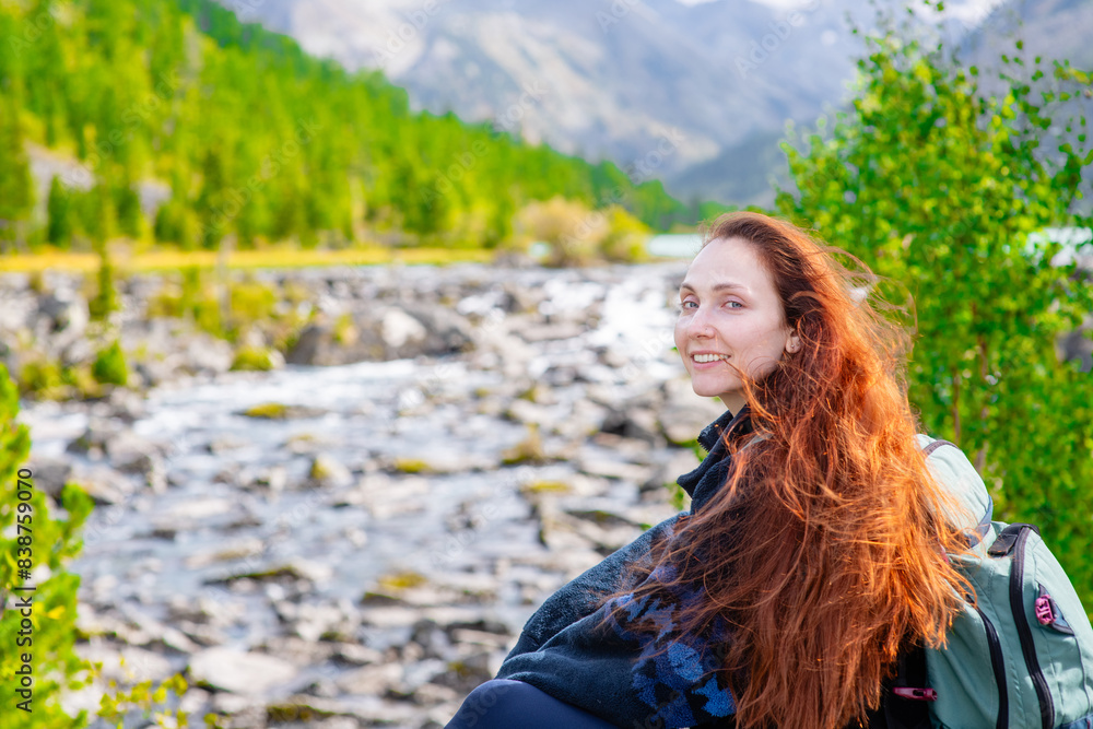 Naklejka premium Portrait of a beautiful redhead long haired woman on the background of mountains and multinsky lake