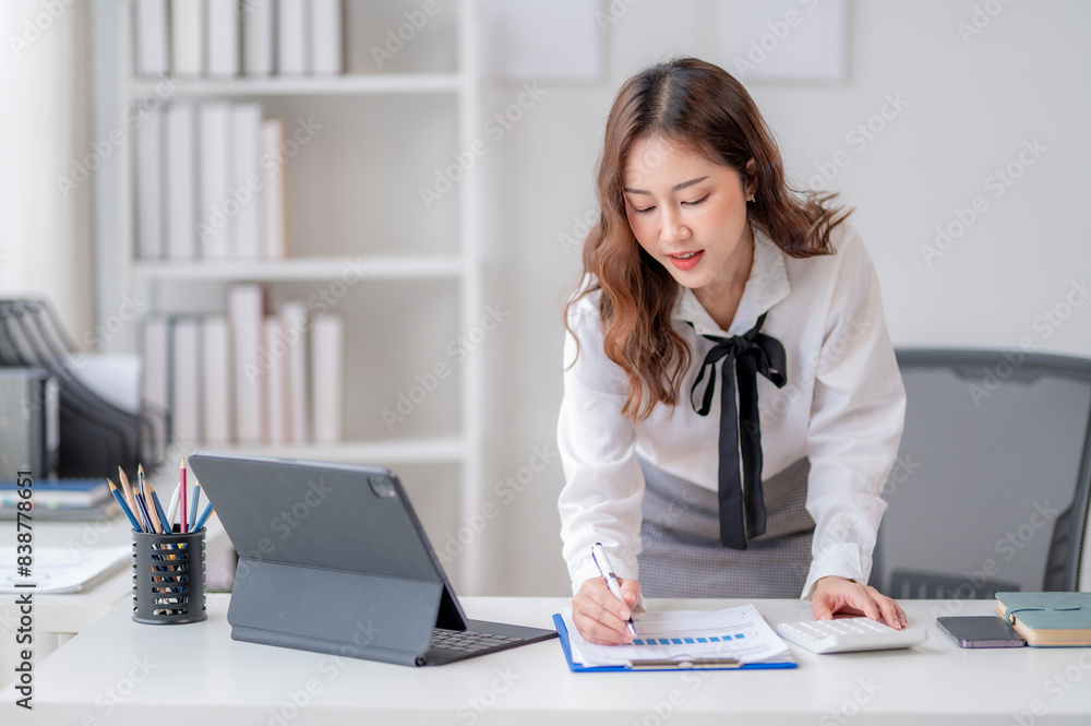 A woman is sitting at a desk with a laptop and a clipboard A woman is sitting at a desk with a laptop and a clipboard