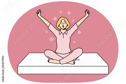 Woman sits on soft mattress and yawns getting ready for healthy sleep furniture concept. Girl in pajamas wakes up with good mood using orthopedic mattress for comfortable night rest