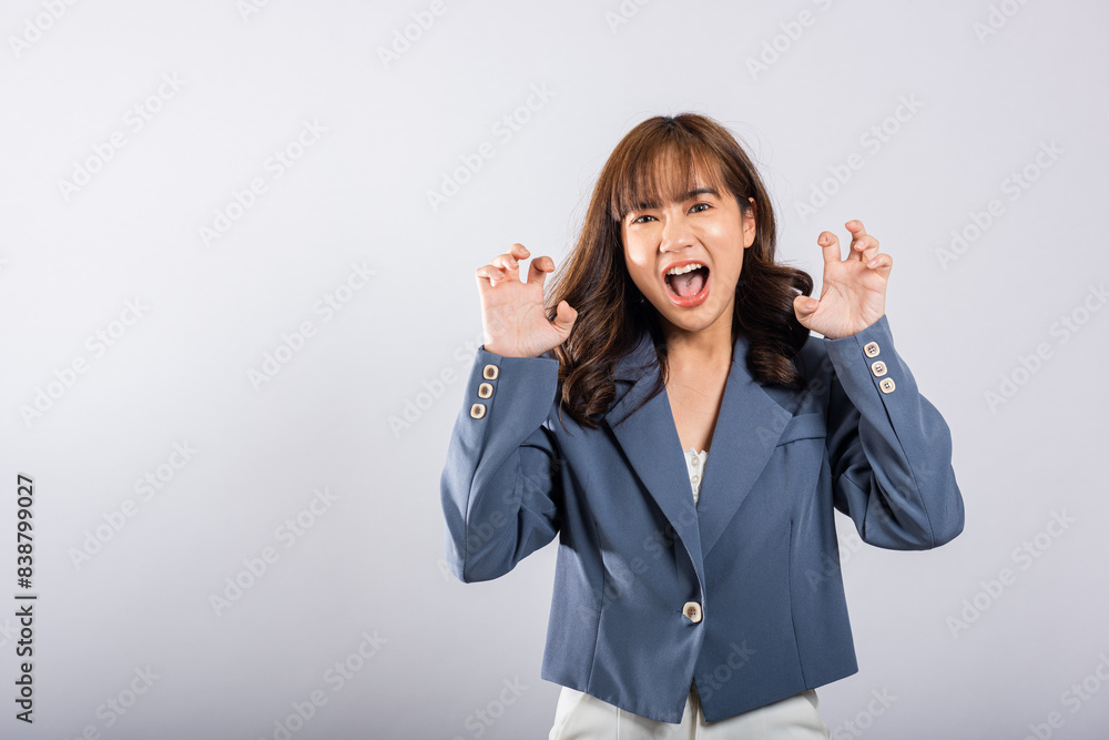 Asian happy portrait beautiful business young woman wearing a suit angry and mad raising fist frustrated and furious while shouting with anger isolated, studio shot on white background and copy space Asian happy portrait beautiful business young woman wearing a suit angry and mad raising fist frustrated and furious while shouting with anger isolated, studio shot on white background and copy space