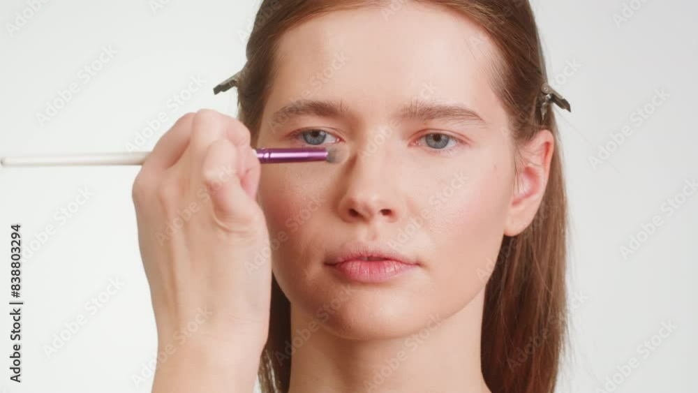 Beauty shot of woman makeup artist applying foundation bb cream on previously applied moisturizing young woman face close-up. Concept of skincare, cosmetics, make up, beauty Beauty shot of woman makeup artist applying foundation bb cream on previously applied moisturizing young woman face close-up. Concept of skincare, cosmetics, make up, beauty