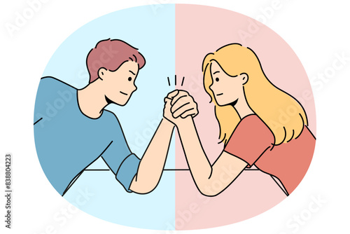 Arm wrestling between couple of man and woman for concept of fighting for leadership in family. Guy with girl compete who is stronger competing for position in company or leadership in team
