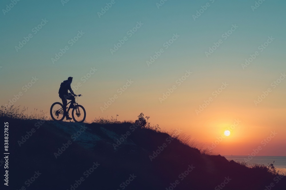 Obraz premium The silhouette of a person on a bicycle also captures the spirit of outdoor adventure.