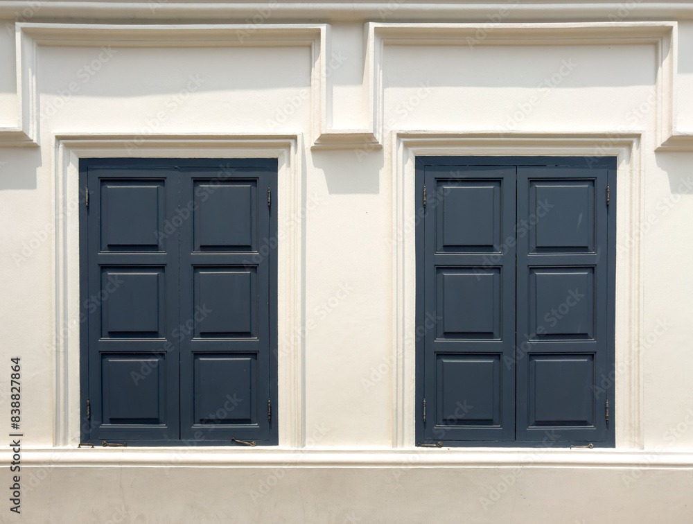 Closed wooden window on a white building wall Closed wooden window on a white building wall