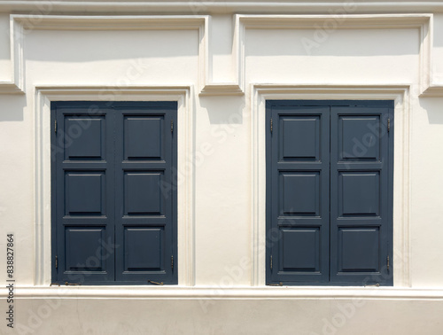 Closed wooden window on a white building wall