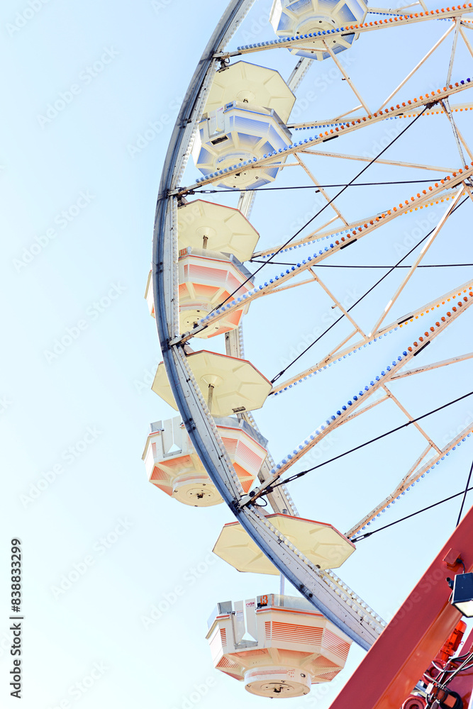 Fototapeta premium Close-up of a Ferris wheel against a clear blue sky at a carniva