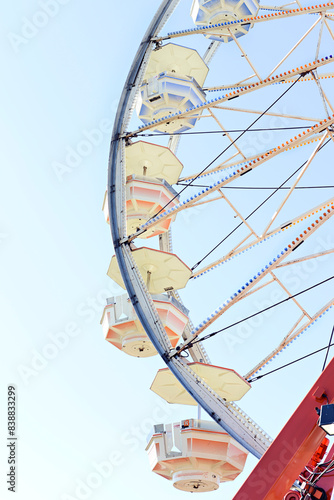 Close-up of a Ferris wheel against a clear blue sky at a carniva