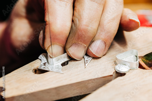 Quadro su tela Close up of jewelers hand working with jewelers saw