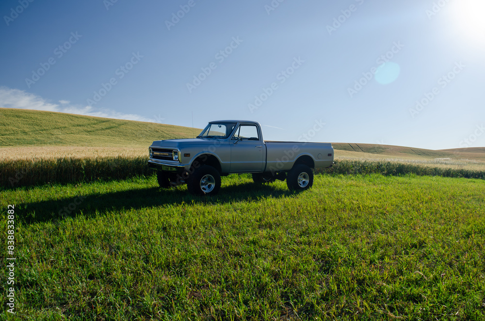Classic truck facing sunrise over rolling hills Classic truck facing sunrise over rolling hills