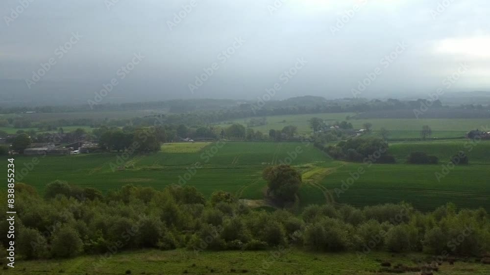 Panning across misty British countryside early morning patchwork farmland fields and meadows Panning across misty British countryside early morning patchwork farmland fields and meadows