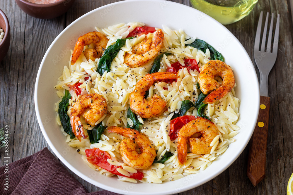 Orzo pasta with shrimp, spinach and tomatoes. Italian Cuisine. Seafood. Orzo pasta with shrimp, spinach and tomatoes. Italian Cuisine. Seafood.