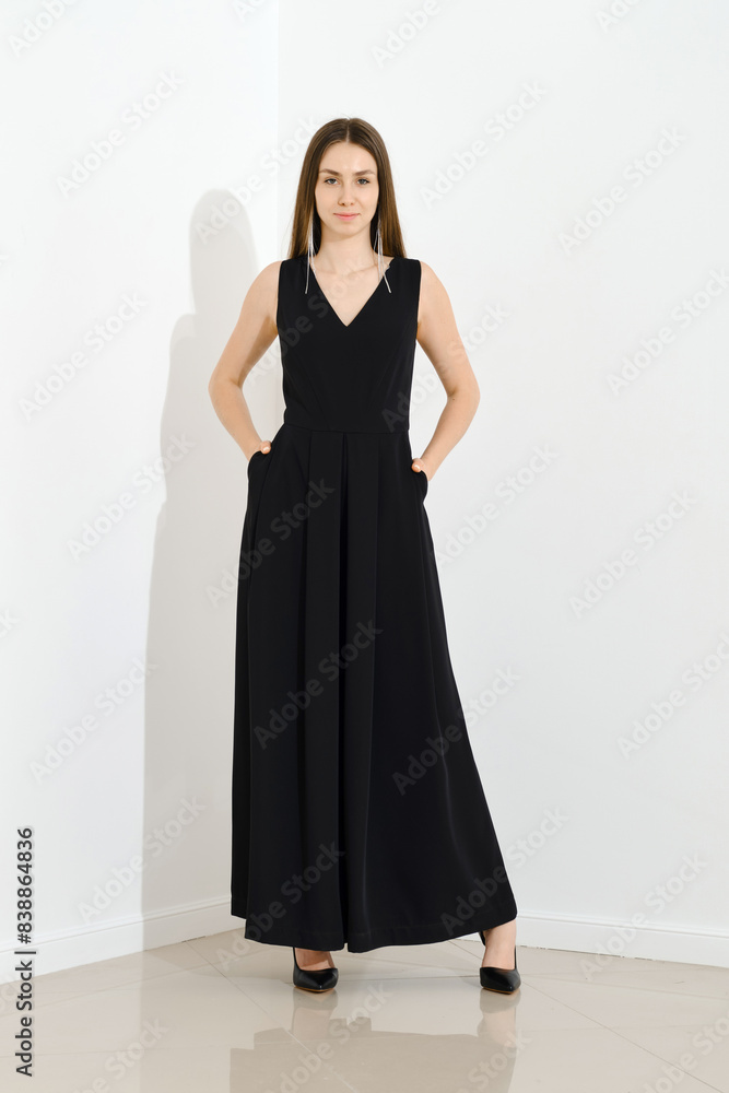 Stylish woman dressed in long sleeveless dress posing Stylish woman dressed in long sleeveless dress posing